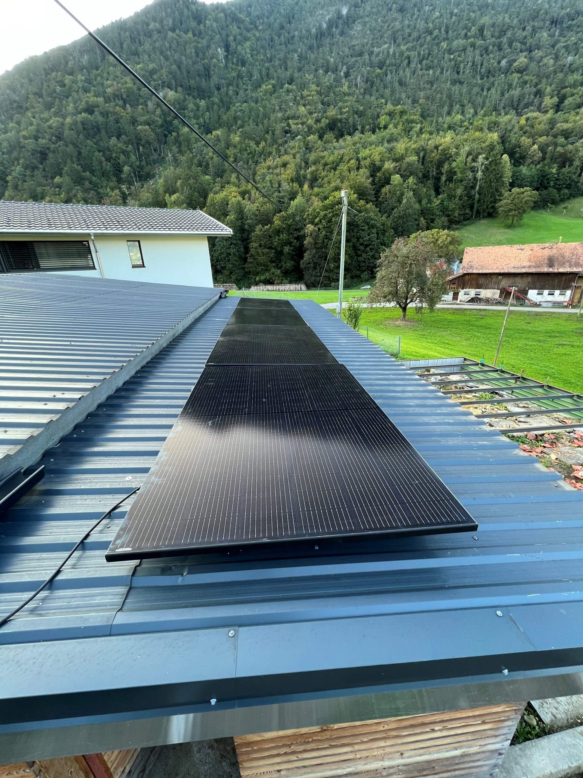 Vier Solarpanelen montiert auf Flachdach mit Trapezblech